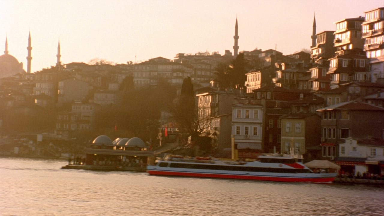 Altın saatte İstanbul’da yamaçtaki ahşap evler ve boğazdan geçen vapur